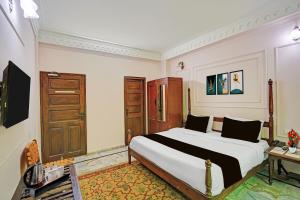 a bedroom with a large bed and a desk at Palette Hotel and Resorts Jodhpur Airport Formerly Royale Plazo in Jodhpur +27 photos