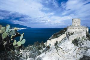 a castle on the side of a cliff next to the ocean at Hotel Marabel in SantʼAlessio Siculo