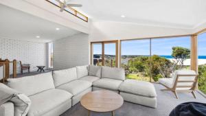 a living room with a white couch and a table at Ocean Ridge House Fairhaven in Aireys Inlet