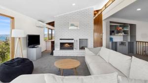 a living room with a couch and a fireplace at Ocean Ridge House Fairhaven in Aireys Inlet
