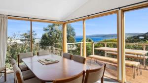 a dining room with a table and views of the ocean at Ocean Ridge House Fairhaven in Aireys Inlet