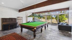 a living room with a pool table and a piano at Ocean Ridge House Fairhaven in Aireys Inlet +2 photos