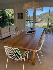 a dining room table with chairs and a large window at Drift - Luxury, location and ocean views in Wye River