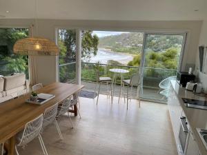 a kitchen and dining room with a view of the ocean at Drift - Luxury, location and ocean views in Wye River