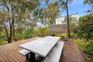 a bench on a wooden deck with a table at Fairhaven Escape in Aireys Inlet