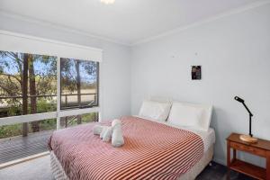 a bedroom with a bed with two stuffed animals on it at Fairhaven Escape in Aireys Inlet