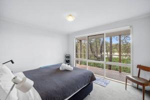 a bedroom with a bed and a large window at Fairhaven Escape in Aireys Inlet