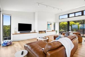 a living room with a couch and a tv at Hakea Ridge in Aireys Inlet