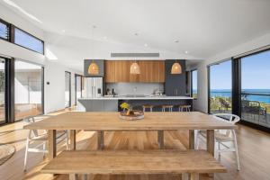 a kitchen and dining room with a large wooden table at Hakea Ridge in Aireys Inlet +22 photos
