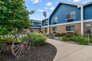 a building with a wheel in front of it at AmericInn by Wyndham Sauk Centre in Sauk Centre
