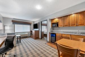 a living room with a kitchen and a dining room at AmericInn by Wyndham Sauk Centre in Sauk Centre