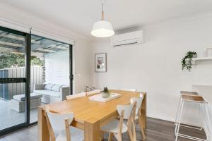 a kitchen and dining room with a wooden table and chairs at Merihaven in Apollo Bay