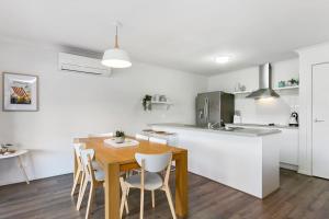 a kitchen and dining room with a wooden table and chairs at Merihaven in Apollo Bay