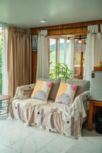 a bed sitting in a room with windows at Nj homestay in Ban Thung Phan Ha