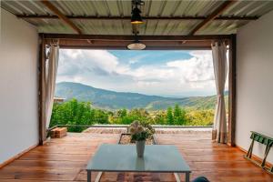 a patio with a table and a view of the mountains at Nj homestay in Ban Thung Phan Ha