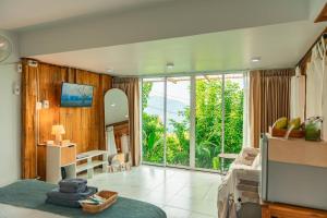 a living room with a television and a large window at Nj homestay in Ban Thung Phan Ha