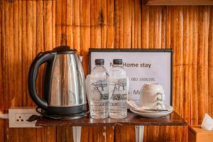 a tea kettle and two bottles on a shelf at Nj homestay in Ban Thung Phan Ha