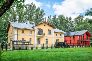 a house and a red barn in a field at Livonia Central Apartments in Valga