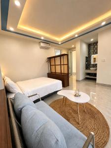a bedroom with a bed and a couch and a table at Lêu Hêu Villa & Coffee in Thôn Mỹ Phước