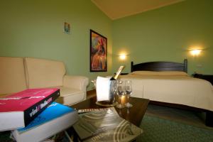 a room with a bed, a table, a chair and a lamp at Hotel Il Duomo in Oristano