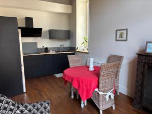 a kitchen with a red table and chairs in a room at Maison Léopoldine 1 , Quartier Historique in Blois +17 photos
