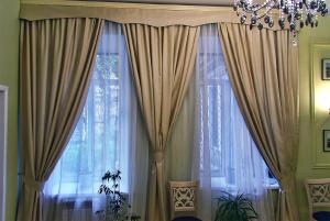 a room with two large curtains and a chandelier at Classic Apartment on Zhukovskoho in Odesa