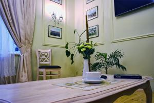 a table with a vase of flowers on it at Classic Apartment on Zhukovskoho in Odesa