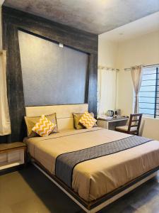 a bedroom with a large bed with pillows on it at Srj's Thaneesh Residency in Ooty