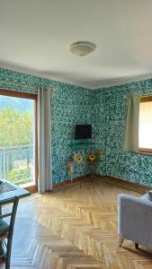 a living room with green walls and a wooden floor at La Tana del Ghiro in Condove