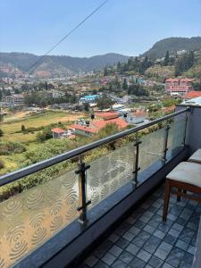 a balcony with a view of a city at Srj's Thaneesh Residency in Ooty