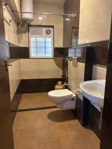 a bathroom with a toilet and a sink at Srj's Thaneesh Residency in Ooty