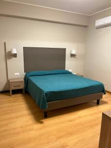 a bedroom with a bed with a green bedspread at Il Gabbiano in Termini Imerese