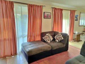 a living room with a couch and orange curtains at Kates Cottage in Aireys Inlet