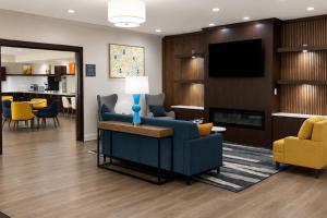 a living room with a blue couch and a tv at Comfort Inn & Suites Concord - Kannapolis in Concord