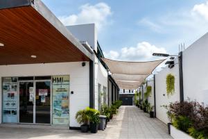a building with awning over a sidewalk with plants at Chenang Private Pool Villa & Cottage in Pantai Cenang