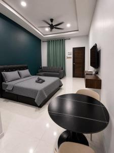 a bedroom with a bed and a table and a couch at Chenang Private Pool Villa & Cottage in Pantai Cenang