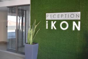 a plant in a vase in front of a green wall at iKON Apartments in Windhoek
