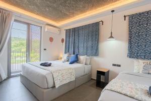 a bedroom with two beds and a window at Ozonizia Family Suites Mai Khao Phuket Yacht Haven in Phuket