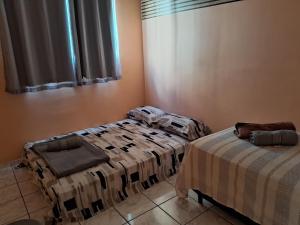 a room with two beds and a window at Apto inteiro 2 quartos Elvamar in Governador Valadares