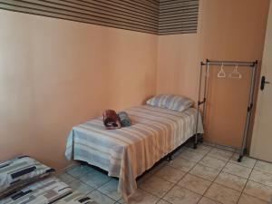 a bedroom with a bed with a purse on it at Apto inteiro 2 quartos Elvamar in Governador Valadares