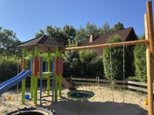 a playground with a swing set in the sand at Ferienwohnung mit Loggia im Teutoburger Wald in Bredenborn
