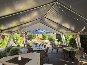 a patio with tables and chairs under a tent at Ferienwohnung mit Loggia im Teutoburger Wald in Bredenborn