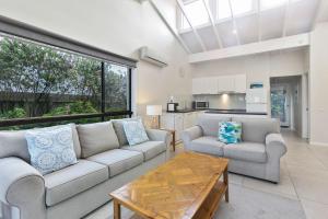 a living room with two couches and a table at Beachside Villa in Apollo Bay