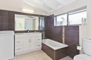 a bathroom with a tub and a sink and a toilet at Beachside Villa in Apollo Bay