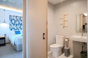 a bathroom with a toilet and a sink and a bed at Ozonizia Family Suites Mai Khao Phuket Yacht Haven in Phuket +126 photos