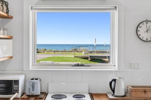 a kitchen window with a view of the ocean at Beachfront Apartment at Apollo in Apollo Bay