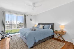 a bedroom with a bed and a large window at Beachfront Apartment at Apollo in Apollo Bay +7 photos