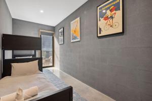 a bedroom with a bed and a gray wall at Bimbadeen Bliss in Aireys Inlet