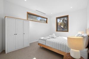a white bedroom with a bed and a cabinet at Bimbadeen Bliss in Aireys Inlet +17 photos