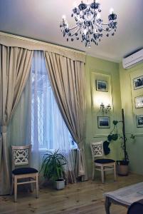 a living room with a chandelier and a window at Classic Apartment on Zhukovskoho in Odesa